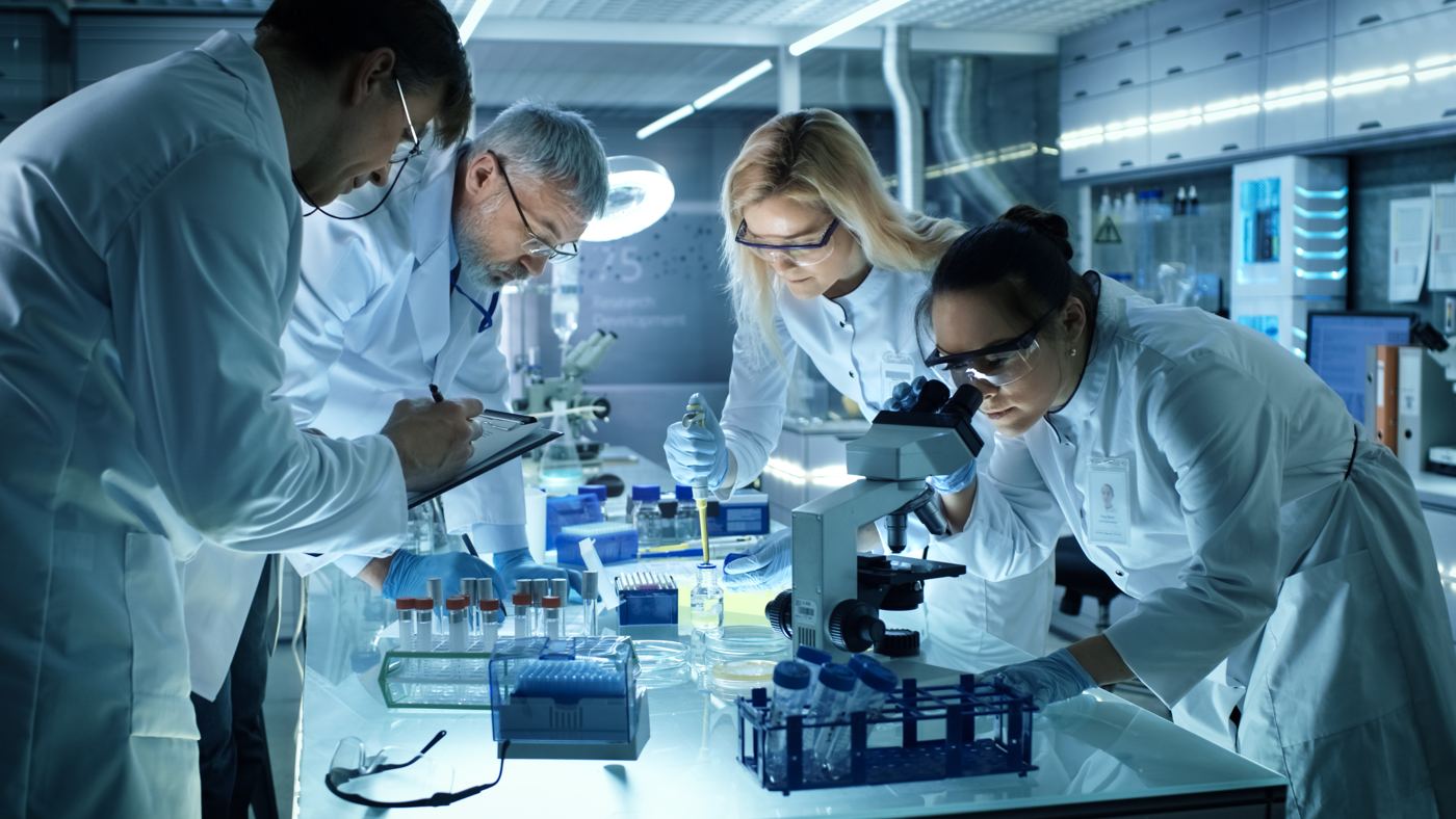 Laboratory scientists working with samples, pipettes and a microscope