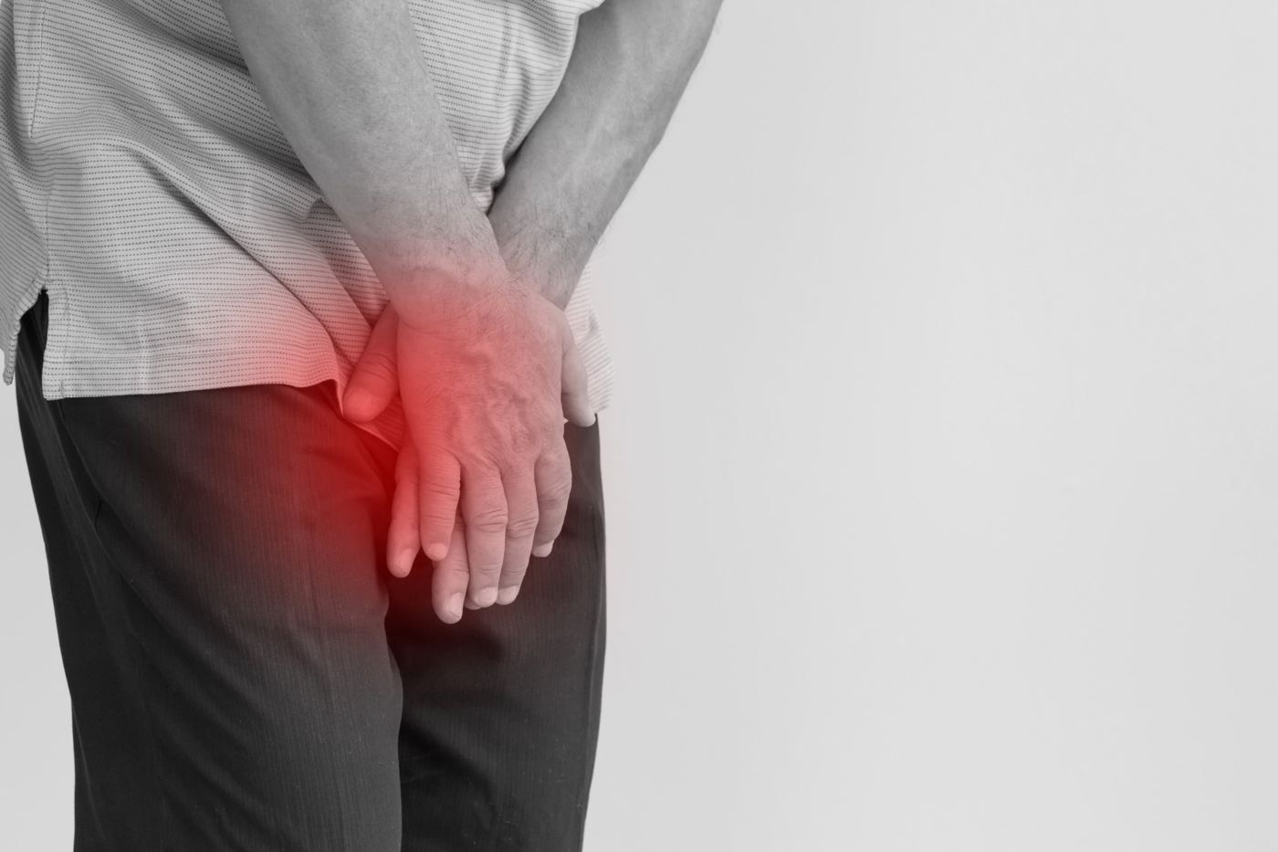 Man holding his lower abdomen with discomfort highlighted